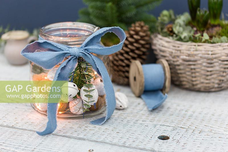 Jar filled with decorated walnuts and LED lights, finished with ribbon 