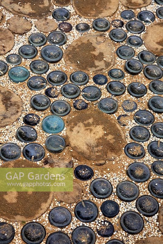 Glass bottles and timber rounds used as paving materials