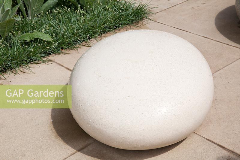Large round smooth white stone as garden sculpture. Brewin Dolphin Garden, RHS Chelsea Flower Show. Designer Robert Myers