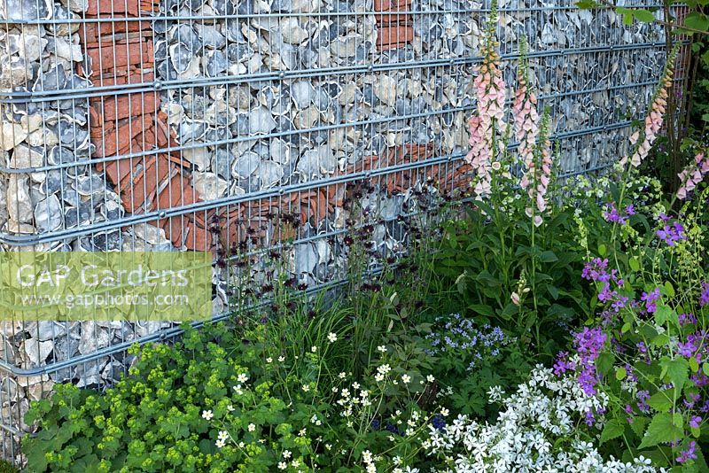 Decorative brick and flint wall contained within steel gabion cages. Brewin Dolphin Garden Chelsea Flower Show 2016