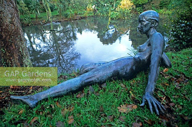 Reclining female nude bronze sculpture beside pond at Sausmarez Manor, Channel Islands