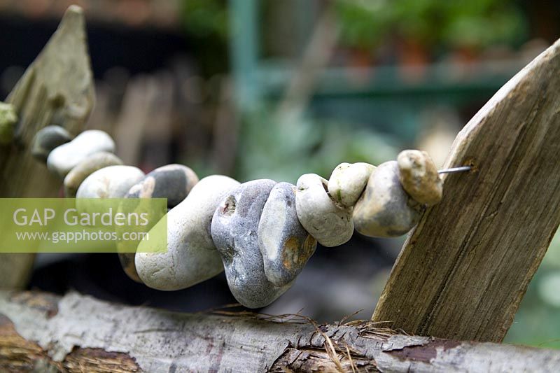 Rustic chestnut fence with detail of threaded beach pebbles