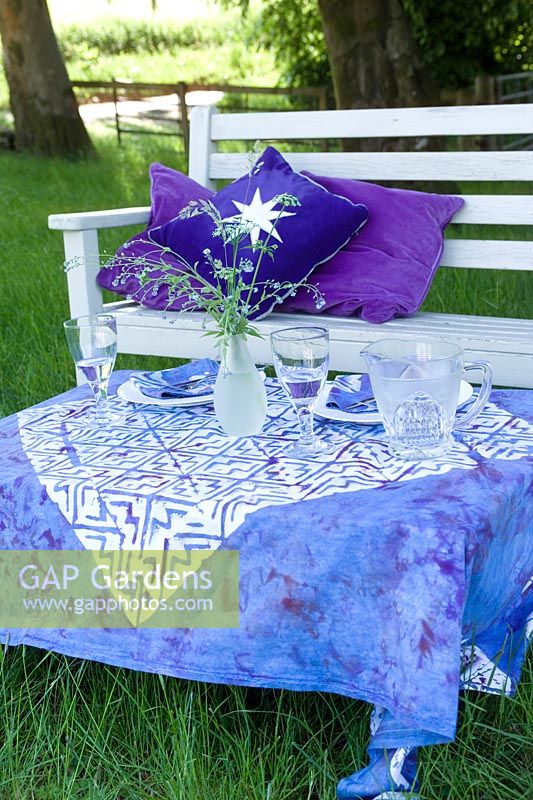 Summer scene of table & seat with blue & white decoration for an al fresco meal