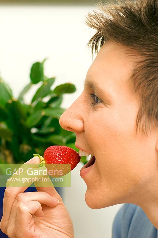 Young lady eats strawberry
