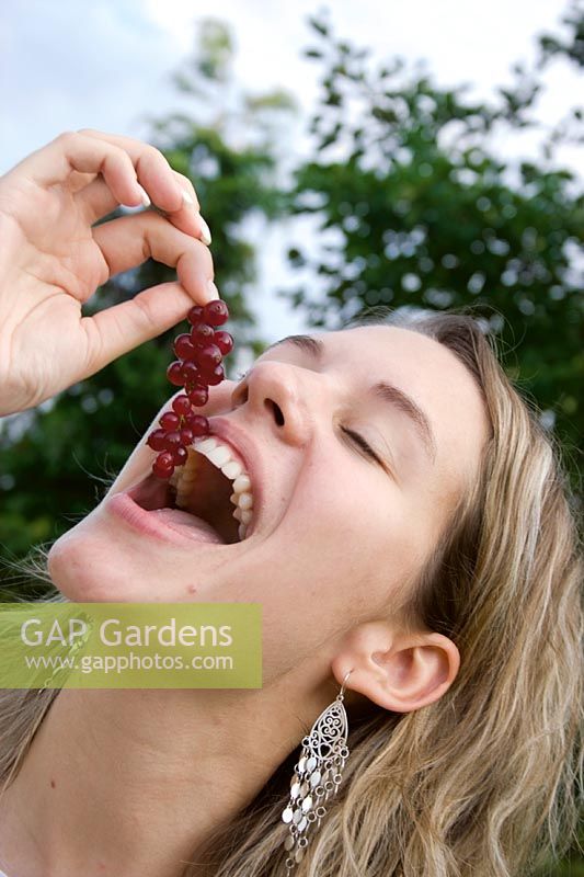 Young lady  eats red currant