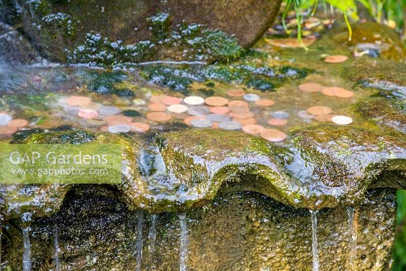 Barnsley House Gardens, Gloucestershire, UK. water feature with coins thrown in for good luck