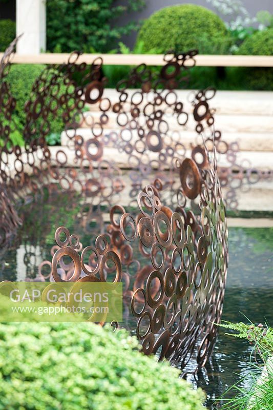 Copper ring sculpture next to pond,The M+G Garden, des. Andy Sturgeon.