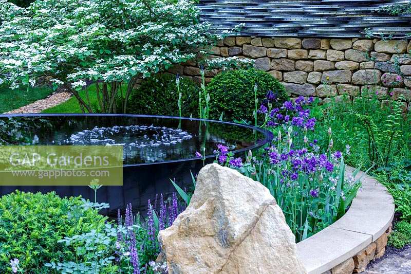 RHS Chelsea Flower Show 2014.  The 'Tour De Yorkshire' garden, designer Alastair W Baldwin, sposor Yorkshire.com. Large reflecting 'dish' pond. 