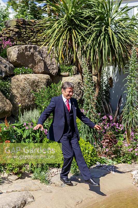 RHS Chelsea Flower Show 2014.  Alan Titchmarsh 'dipping his toe' into his own garden pond. 