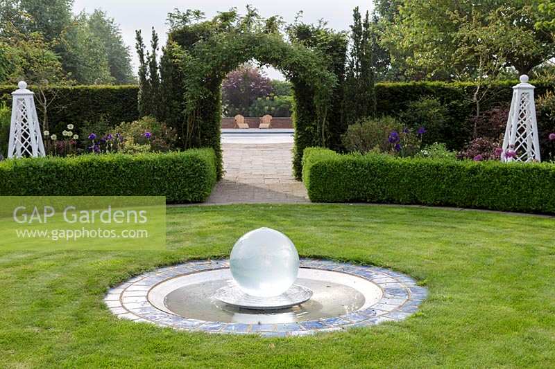 Mitton Manor, Staffordshire. Glass water feature sphere in circular garden lawn