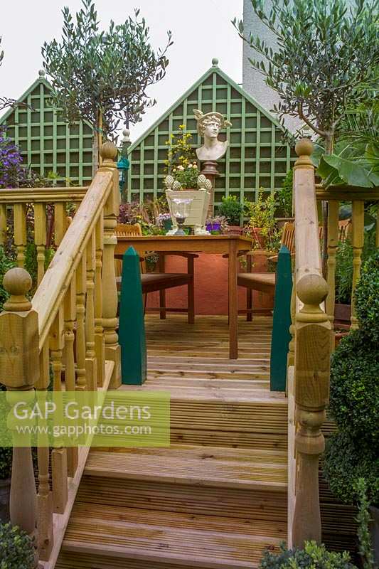 68 Kensington Rd, Bristol ( Gren Johnson ) Small town garden, raised deck with steps leading up to table and chairs.