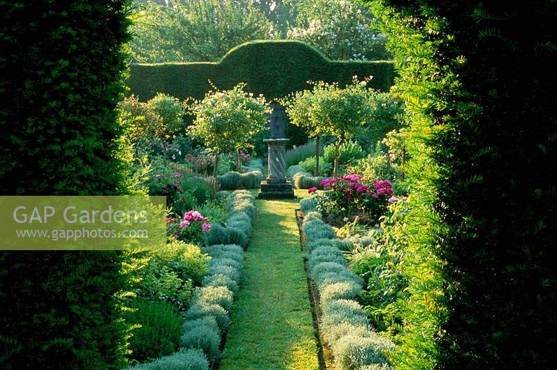Cranbourne Manor Dorset Herb garden with lavender lined grass path leading to sun dial focal point Rosa gallica Versicolor