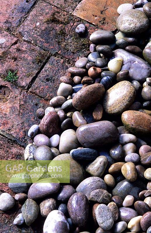 mulch of pebbles beside brick path