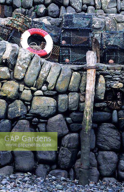Clovelly Devon sea wall made from boulders life ring fishing equipment