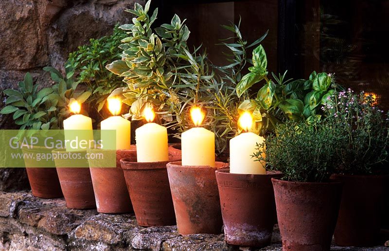 The Oast Houses Hampshire Garden Lighting Candles in terracotta pots on windowsill with potted herbs