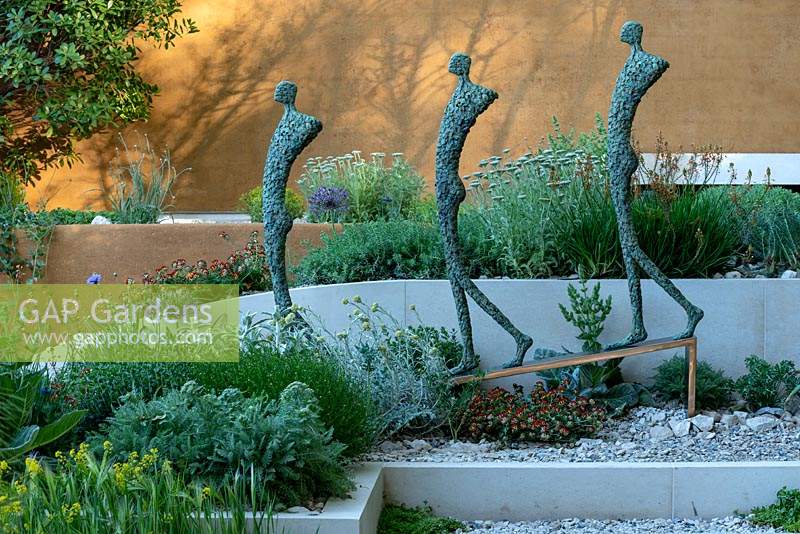Sculpture of three human figures, designed by Michael Speller, in The Dubai Majlis Garden. Designed by Thomas Hoblyn. Sponsored by Dubai. RHS Chelsea Flower Show, 2019.
