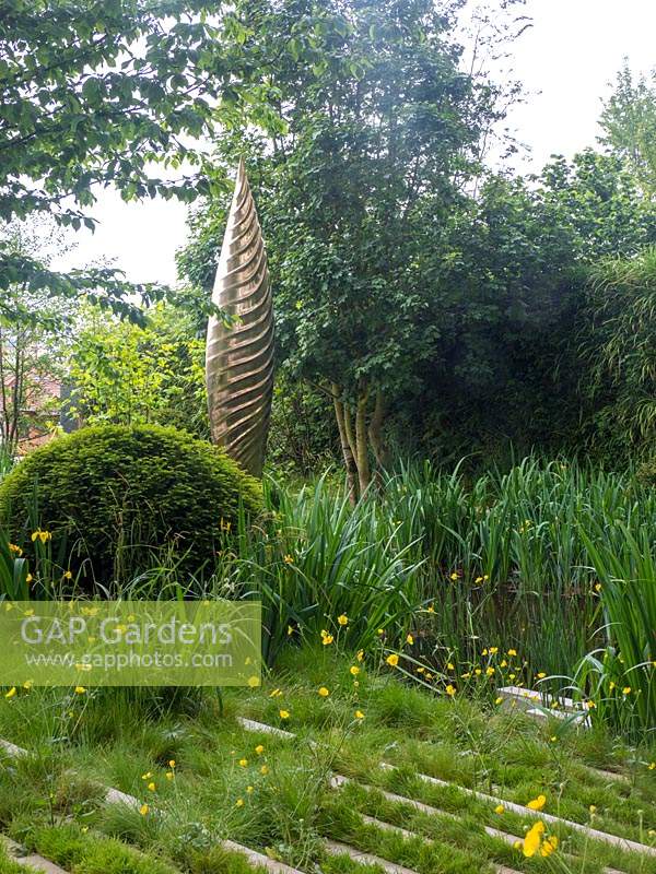 The Savills and David Harber Garden is a green garden depicting a sustainable woodland clearing. Designed by Andrew Duff, Sponsored by David Harber Savills, RHS Chelsea Flower Show, 2019. 