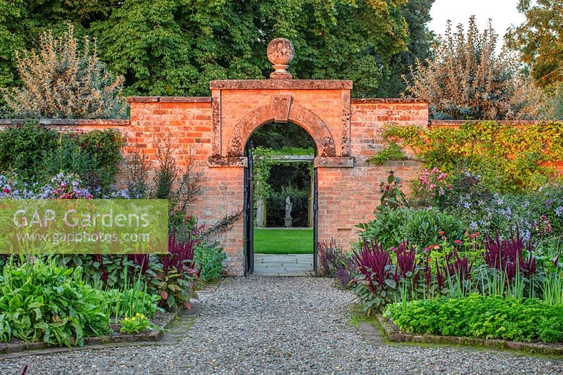 Gate in walled kitchen garden with beds of Amaranthus - Morton Hall Gardens, Worcestershire
