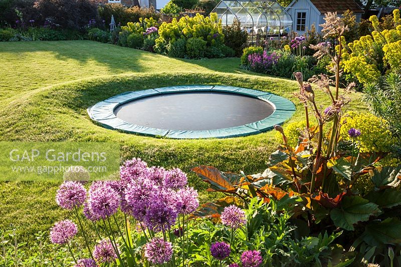 View of garden with sunken trampoline.  