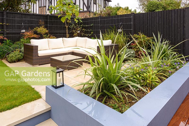 An outdoor sofa and chairs and built-in seating with rendered brickwork. 