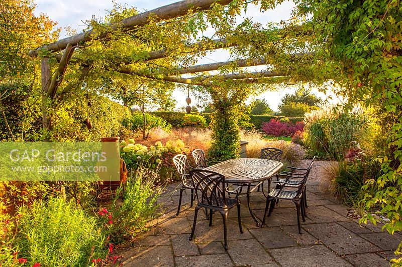 Pergola with patio, metal table and chairs
