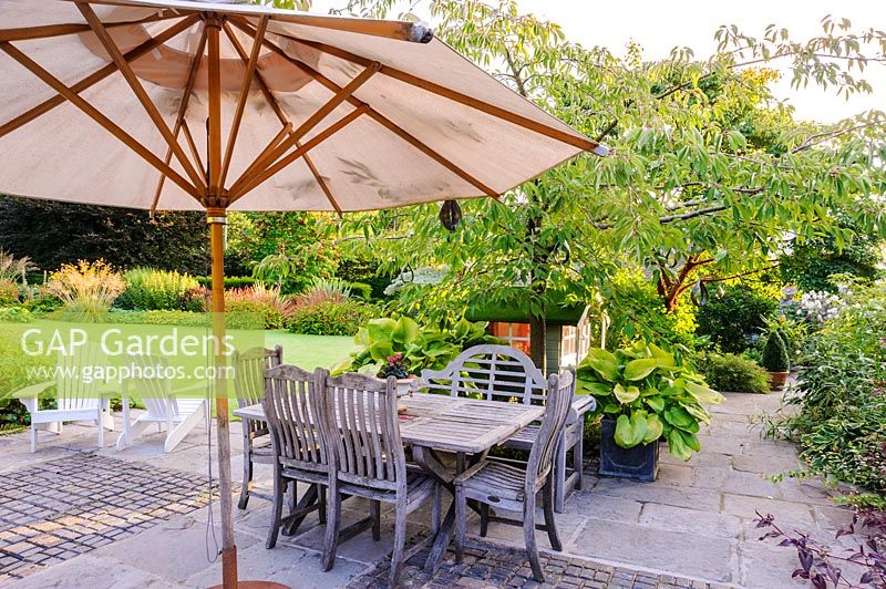 Wooden dining table and parasol on terrace, Newport, Wales