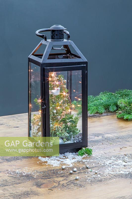 Completed festive scene lantern with LED lights on workbench