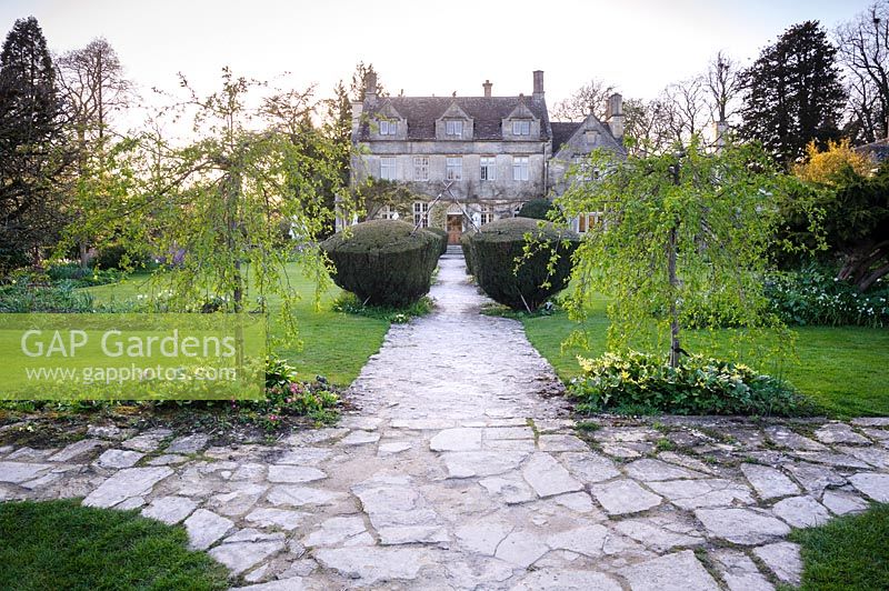 View down path with symmetrical planting at Barnsley House, Cirencester, Glos, UK. 