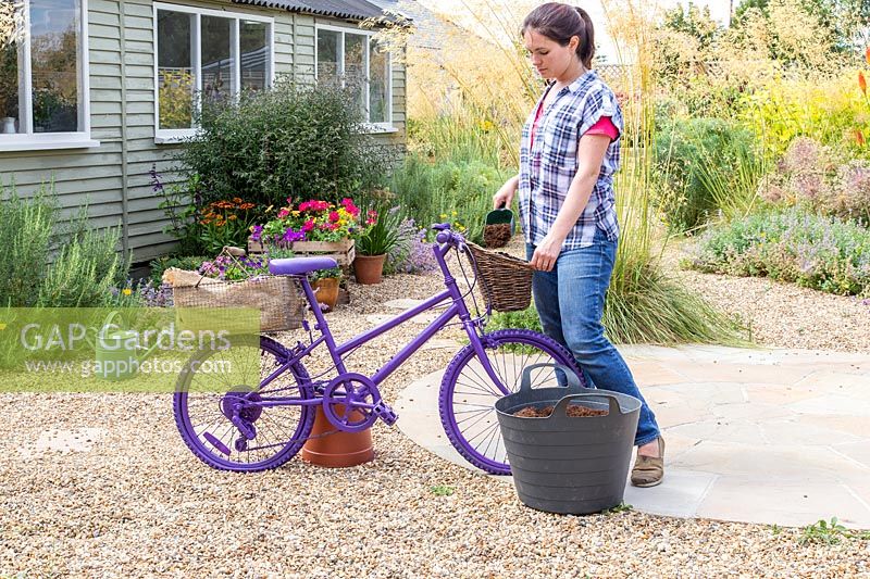 Woman adding compost to lined basket
