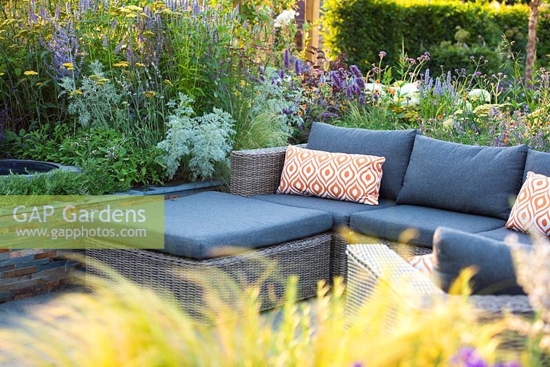 Seating area surrounded by raised beds. The RNIB Community Garden. Designers: Steve Dimmock, Paula Holland, RHS Hampton Court Palace Flower Show, 2018.