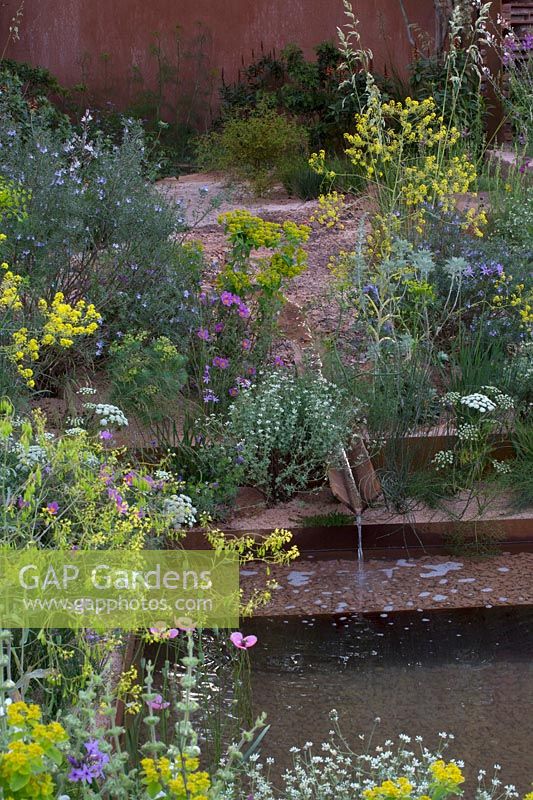 Water rill leading into a stepped gravel pool. The M and G Garden, Sponsor: M and G Investments, RHS Chelsea Flower Show, 2018.