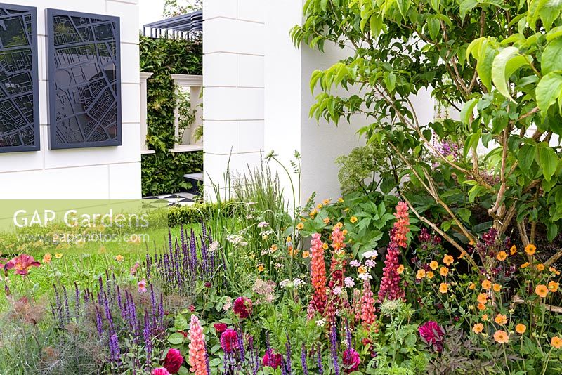 Courtyard Garden with Ashlar-clad walls, living walls with Ferns  and Salvia, Lupins, Geum and Roses - New West End Garden - Sponsor: New West End Company Sir Simon Milton Foundation - RHS Chelsea Flower Show 2018
