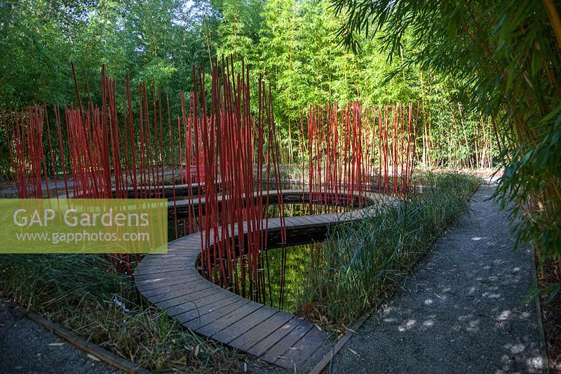 Tall bambooand winding pathways with red poles. Pres du Goualoup. Festival des Jardins 2018, Chaumont sur Loire, France  