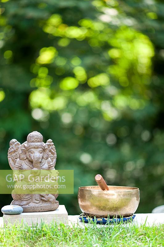 Ganesha sculpture beside a singing bowl.