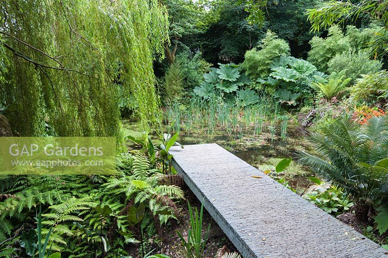 Adaptation of a Chelsea gold  medal winning garden by Darren Hawkes, reconfigured to give access to an area of the garden full of large foliage plants with a tropical feel