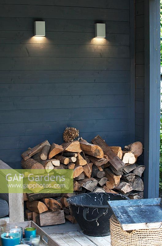 View of rustic wood pile in cosy garden shed area. 