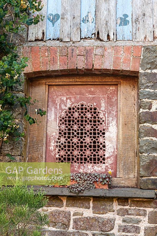 Decorative carved stone window from India. Plaz Metaxu Garden, Devon, UK. 