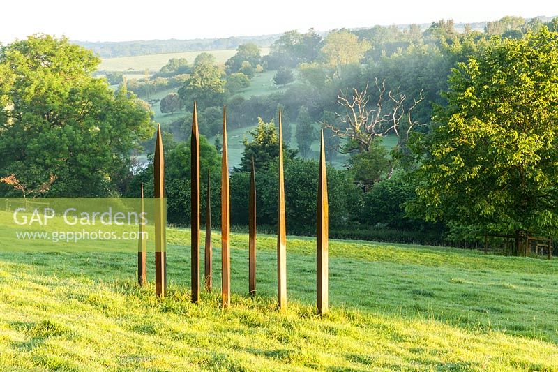 Metal sculpture in the form of standing stones, Plaz Metaxu Garden, Devon, UK. 
