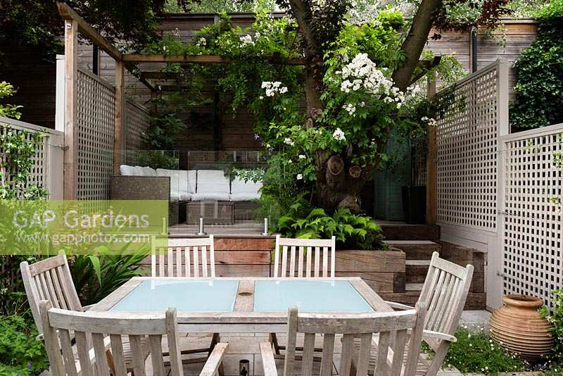 View of multi-level urban garden, with dining area and relaxing area. 
