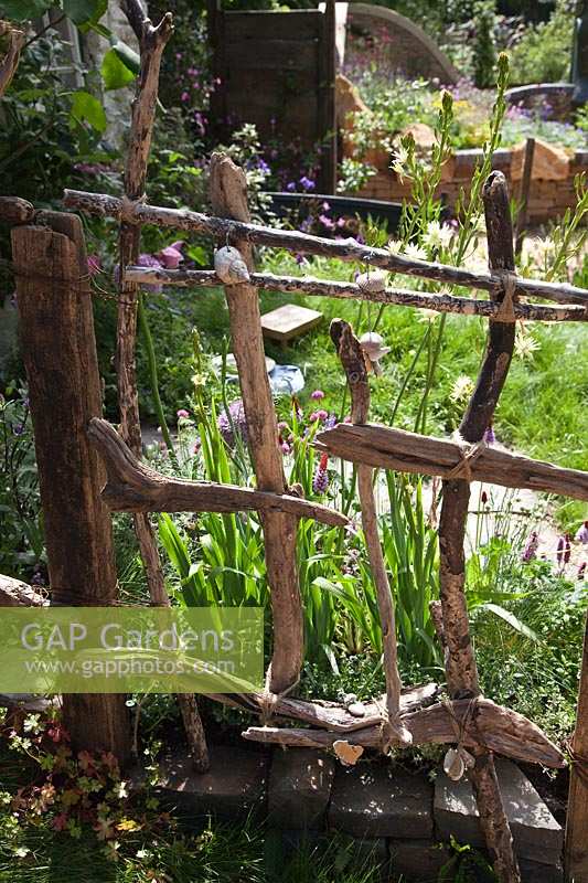 Driftwood fence. 'Postcard From Wales' Garden, RHS Chelsea Flower Show.