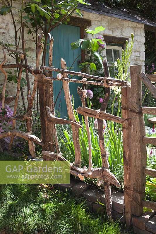 Driftwood Garden gate. 'A Postcard From Wales' Garden, RHS Chelsea Flower Show.