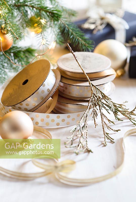 Gold painted foliage with spools of ribbon and baubles