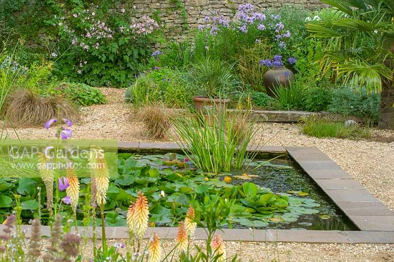 Walled garden with pond, water lilies and gravel garden, Meadow Nursery, Wells, Somerset, UK