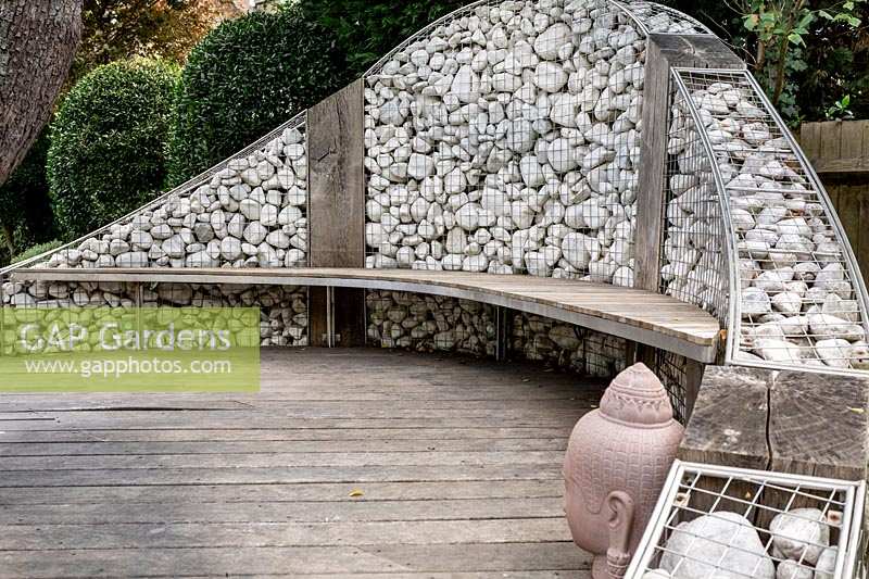 Gabion wall with a hardwood seating attached, with wood decking