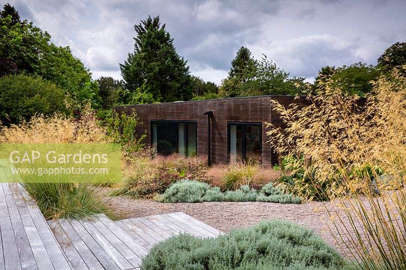 The house and surrounding mixed borders in contemporary country garden near Winchester, Hants, UK. Designed Elks-Smith Garden Design. 