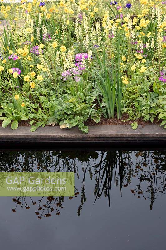 Naturalistic planting and pool in show garden. The Great Outdoors Garden, Sponsored by Allgreen Group, Handspring Design, Knowl Park Nurseries. RHS Chatsworth Flower Show, 2018.

