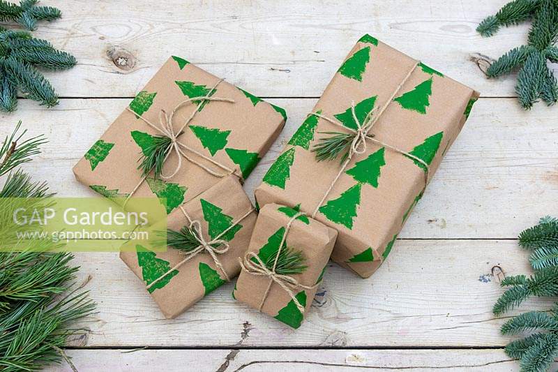 Pile of Christmas presents wrapped with hand-printed wrapping paper and tied up with 
string