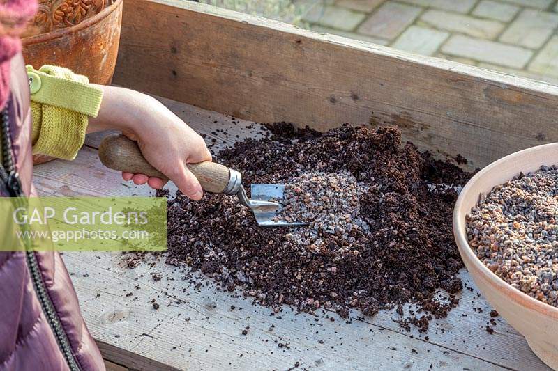Woman adding horticultural grit to compost to make it free draining.