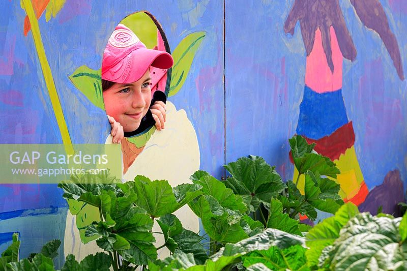 'O Beoley-wan-Kenobi' school show garden, a pupil poses for the camera 
in the head-hole of Star Wars character Yoda, painted onto the back wall of 
the garden