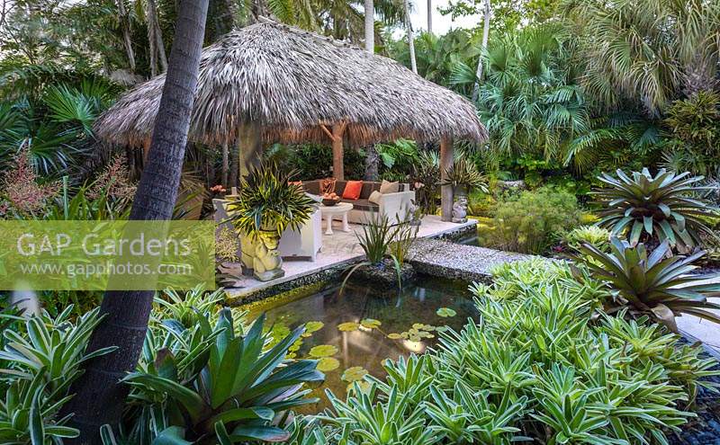 The chickee hut and pond in tropical garden. The Jones Residence, Key West, Florida, USA. Garden design by Craig Reynolds.
